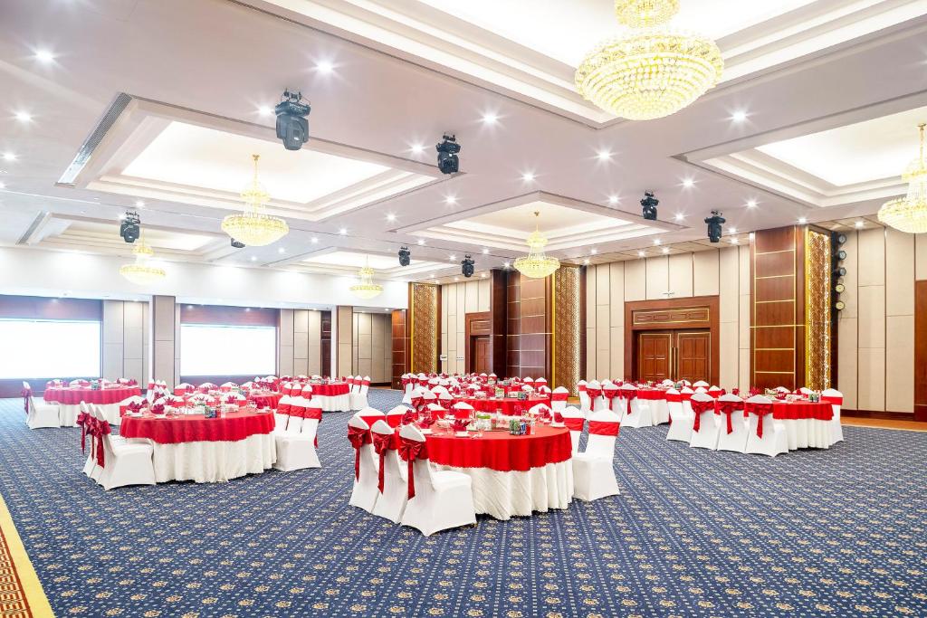 a banquet hall with red and white tables and chairs at DLG Hotel Danang in Da Nang
