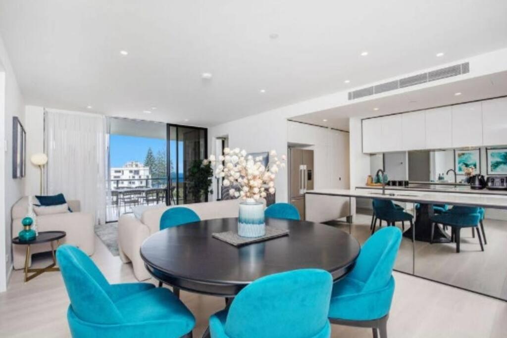 sala de estar con mesa y sillas azules en Magnoli Apartments - Hosted by Burleigh Letting en Gold Coast