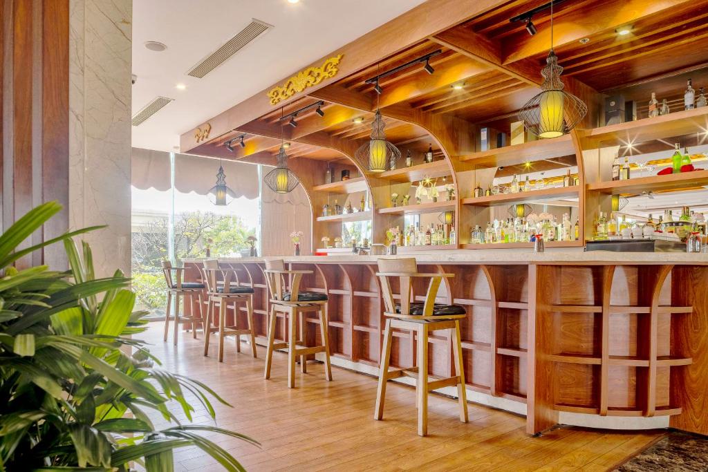 a bar at a restaurant with wooden walls and bar stools at DLG Hotel Danang in Da Nang