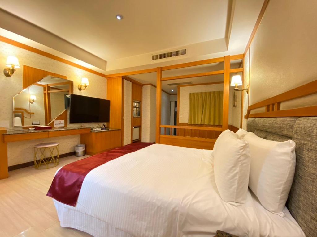 um quarto de hotel com uma cama e uma televisão em I Live Motel em Kaohsiung