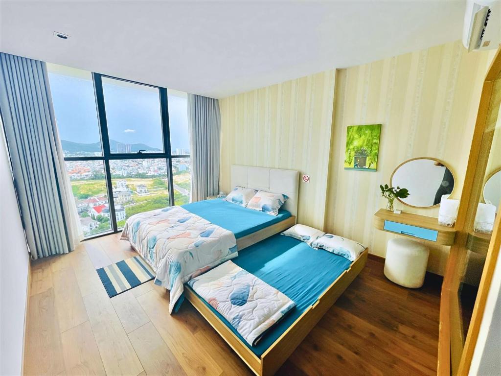 a bedroom with two beds and a large window at Little Cloud Home Vũng Tàu - CSJ Tower in Vung Tau