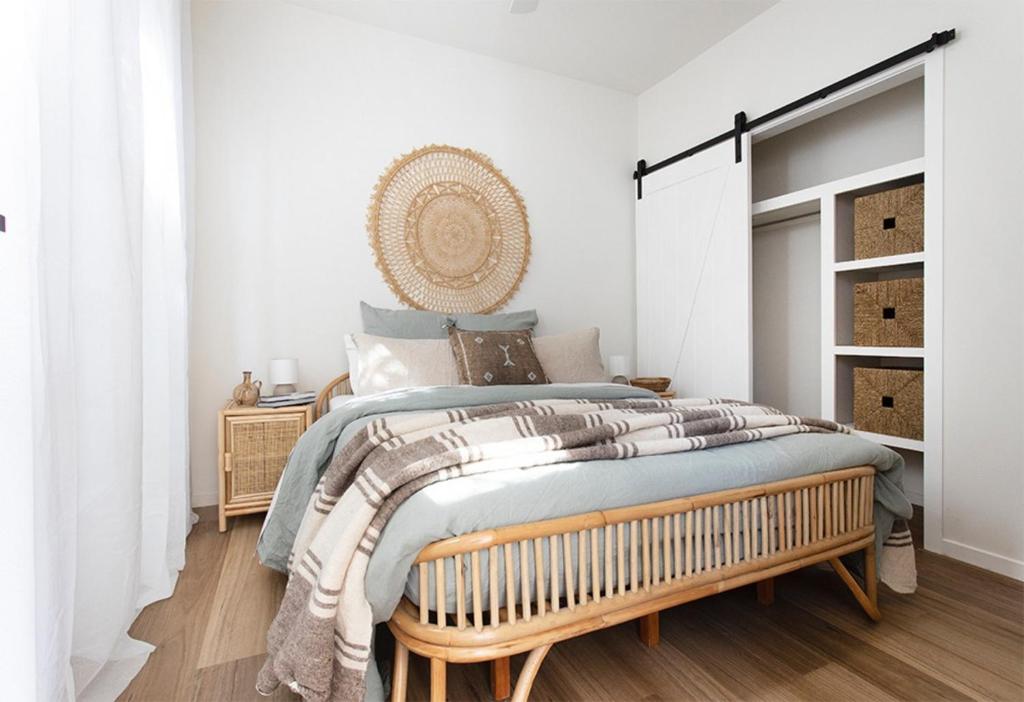 a bedroom with a large bed with a wooden bench at Currumbin Beach 1 bedroom Studio - steps from the beach! in Gold Coast