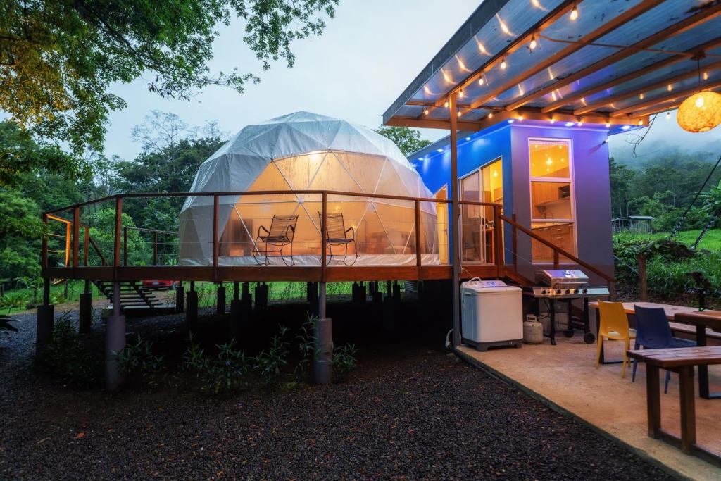 Casa con cúpula de cristal, mesa y sillas en Bitzu Dome-Bijagua Riverside Glamping en Bijagua