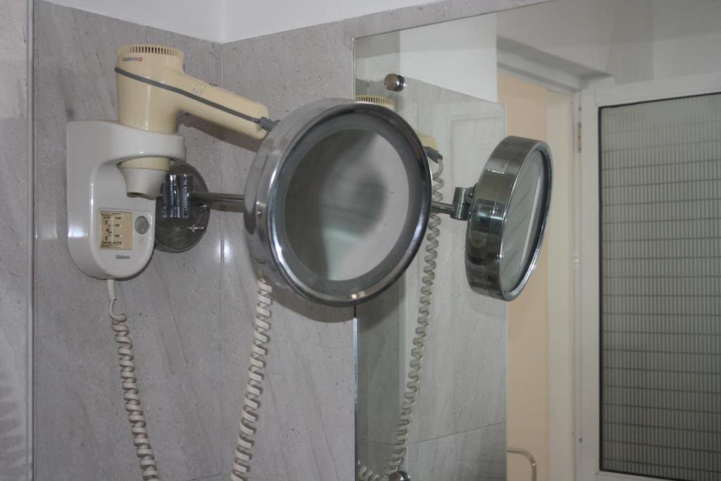 baño con 2 teléfonos y espejo en kandywin Hotels, en Kandy