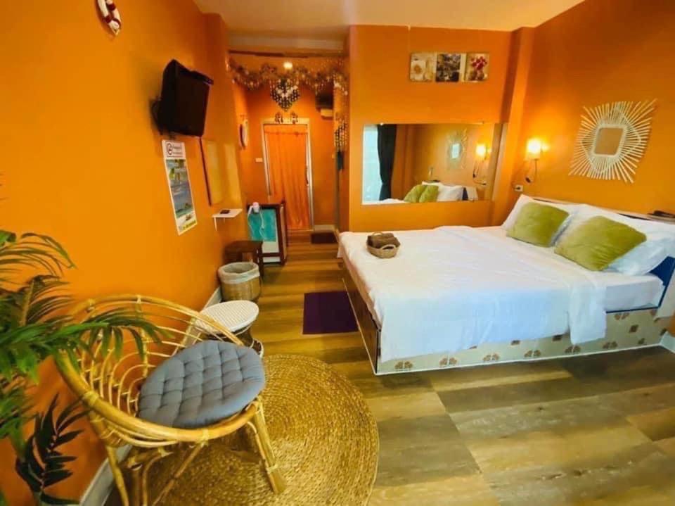 1 dormitorio con cama, silla y espejo en บ้านเนวี่ เกาะล้าน, en Koh Larn