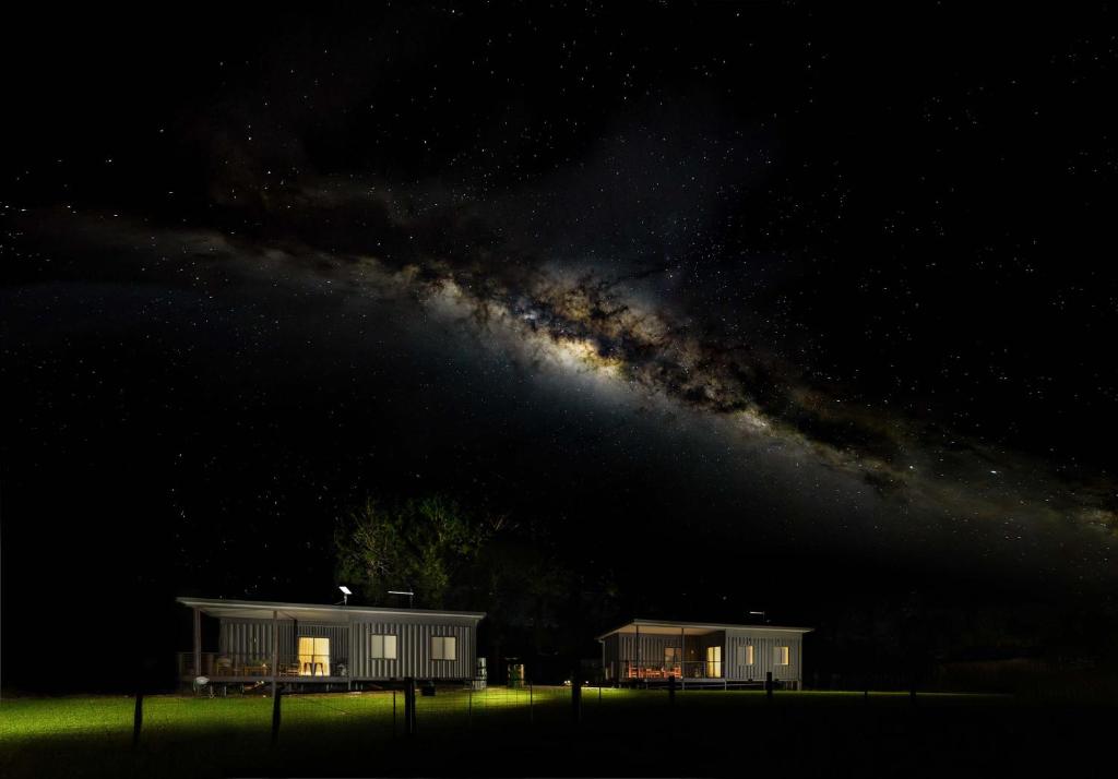 un par de edificios de noche con una galaxia en Contained in Nimbin Accommodation, en Nimbin