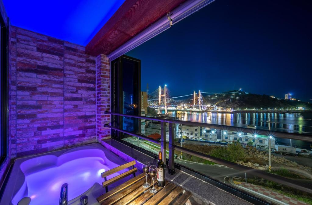 a bath tub on a balcony with a view of a harbor at Yeosu View Foret Pension in Yeosu