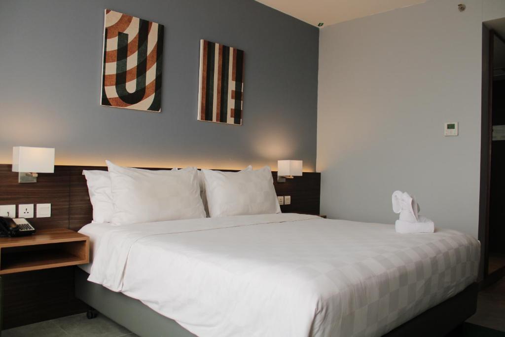 Postel nebo postele na pokoji v ubytování Swiss-Belinn Bogor
