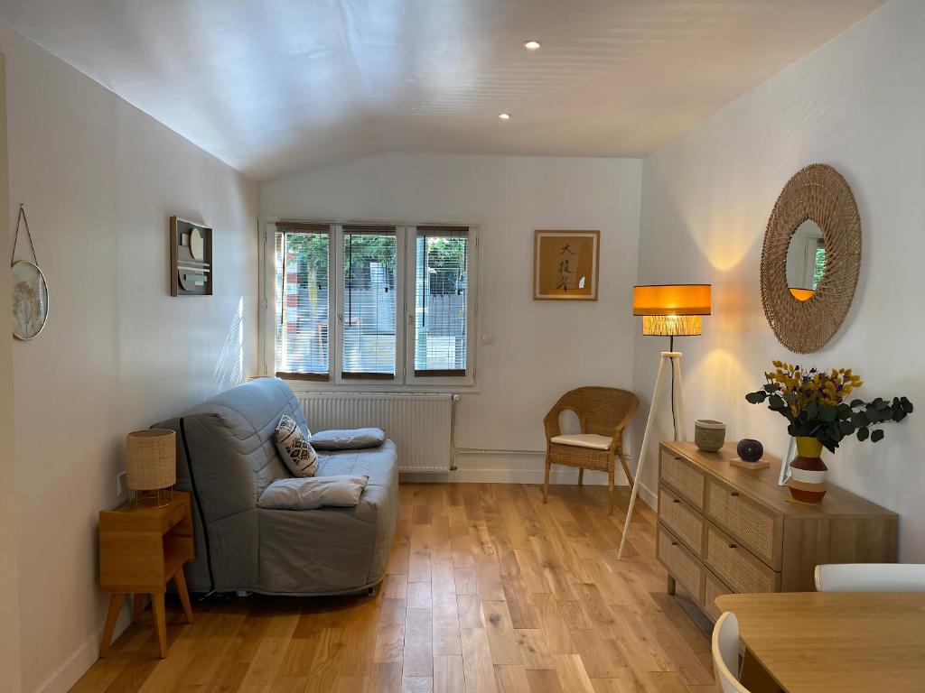 un salon avec un canapé et une chaise dans l'établissement Cocon cosy aux portes de Paris / Joinville-le-Pont, à Joinville-le-Pont