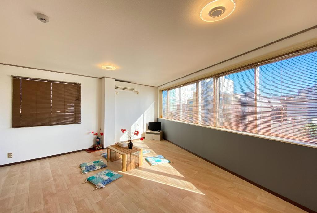 uma sala de estar com uma grande janela com vista em Uhome Mitomi Home 3F em Tóquio