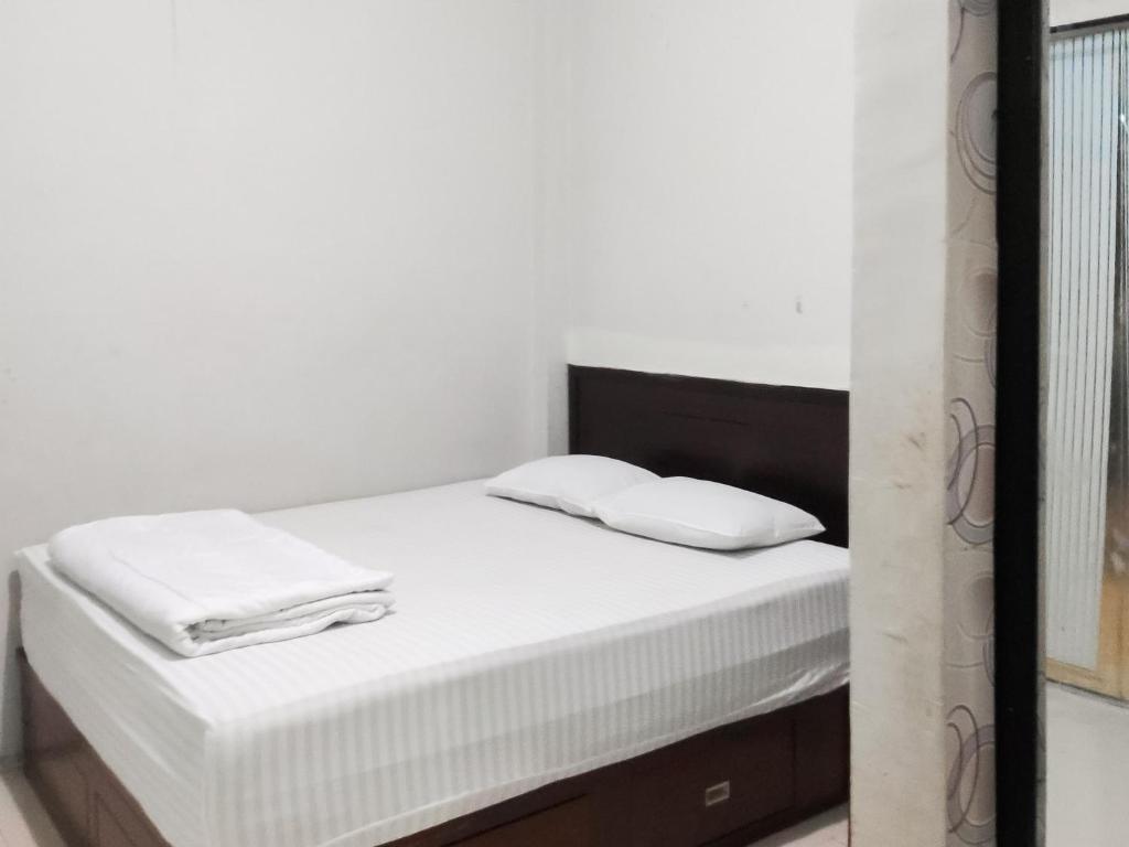 Postel nebo postele na pokoji v ubytování RedDoorz Syariah near Terminal Terpadu Langsa
