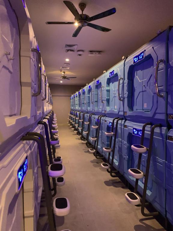 a row of blue train cars with a ceiling fan at PassGo Digital Airport Terminal 2 Soekarno Hatta in Rawabagol
