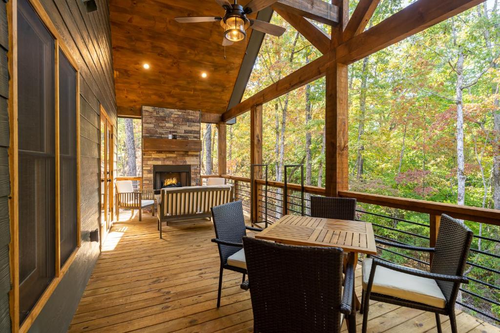 a screened porch with tables and chairs and a fireplace at Peaceful Luxury Cabin, hot tub, games, 3 fireplaces in Blue Ridge