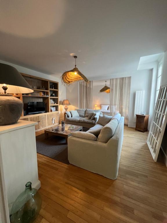 salon z kanapą i stołem w obiekcie Luxe et Charme - Le Carré Saint-Silain - Meublé de tourisme 3 étoiles w mieście Périgueux