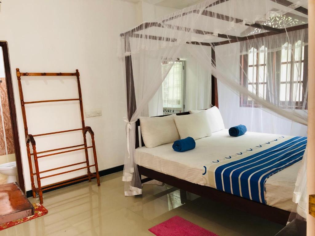 a bedroom with a bed with a canopy at Tiny Royal Palace in Unawatuna