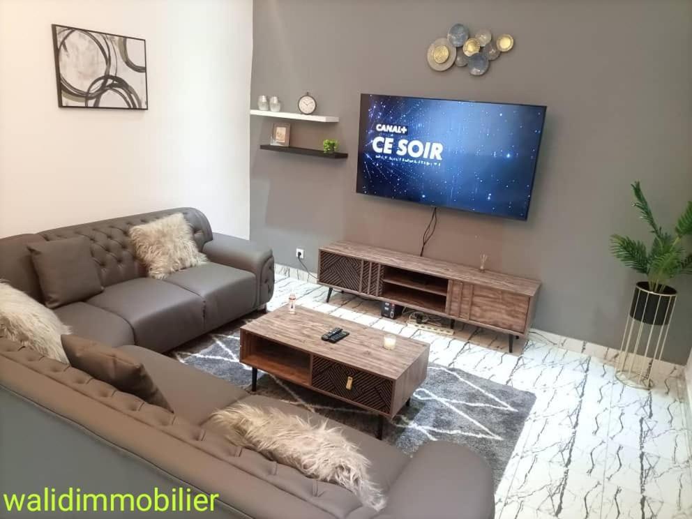 a living room with a couch and a flat screen tv at Appartement chic in Pointe-Noire