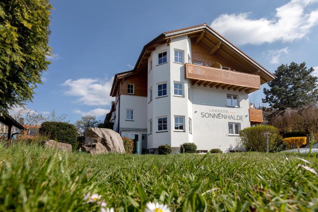 a white house with a wooden roof at Landhotel Sonnenhalde in Bad Boll