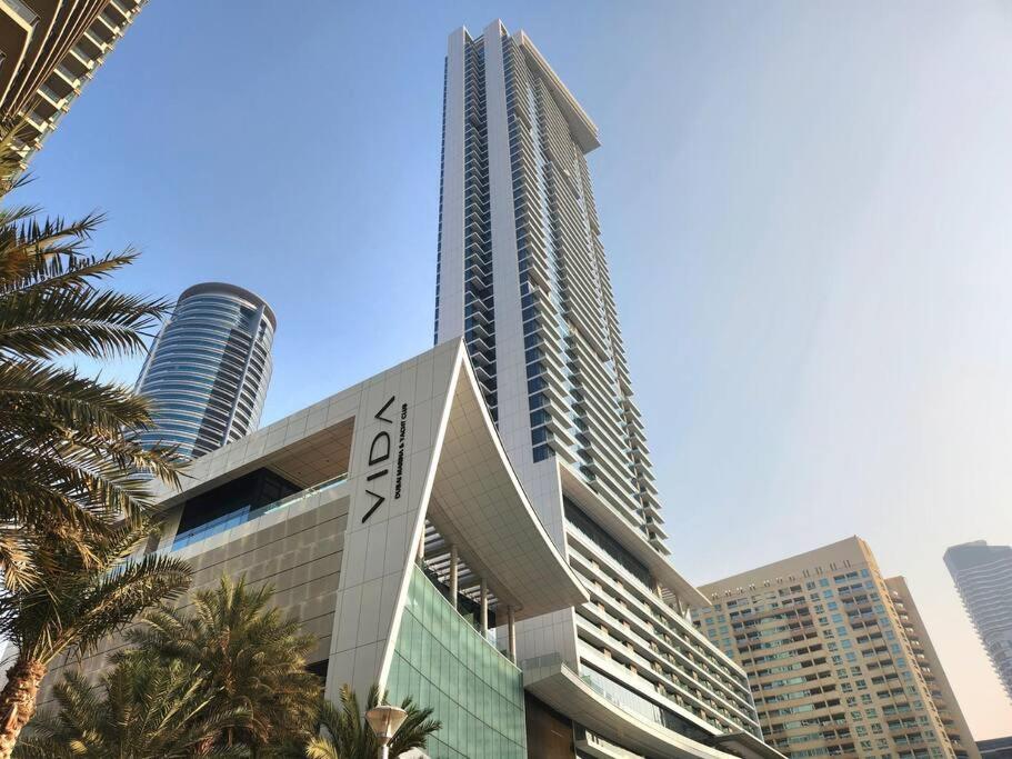 un grand bâtiment avec un panneau dans une ville dans l'établissement Vida Dubai Marina & Yacht Club, 1 BR with Marina and Sea View, à Dubaï