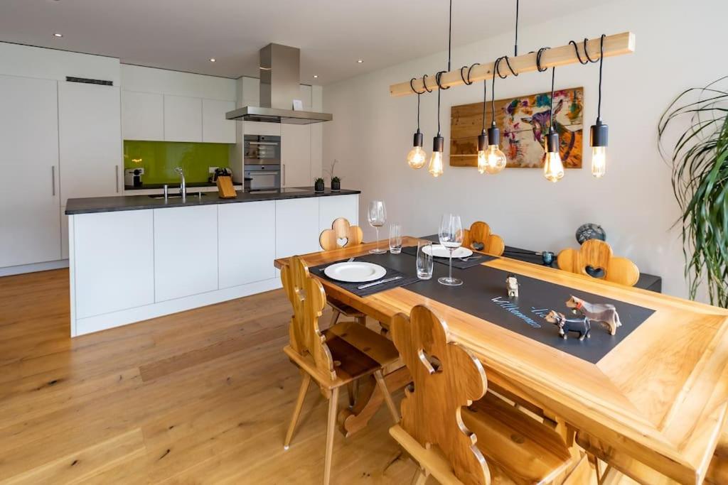 eine Küche mit einem Holztisch und eine Küche mit weißen Schränken in der Unterkunft Wohnung Pulverturm in Appenzell