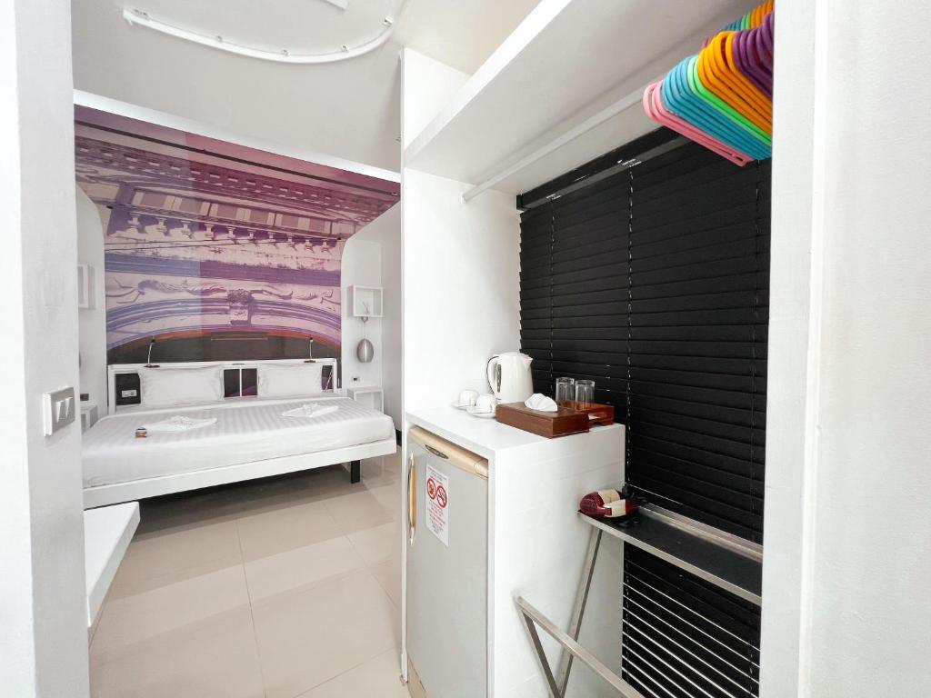 a small kitchen with a refrigerator and a bed at The Color Kata in Kata Beach