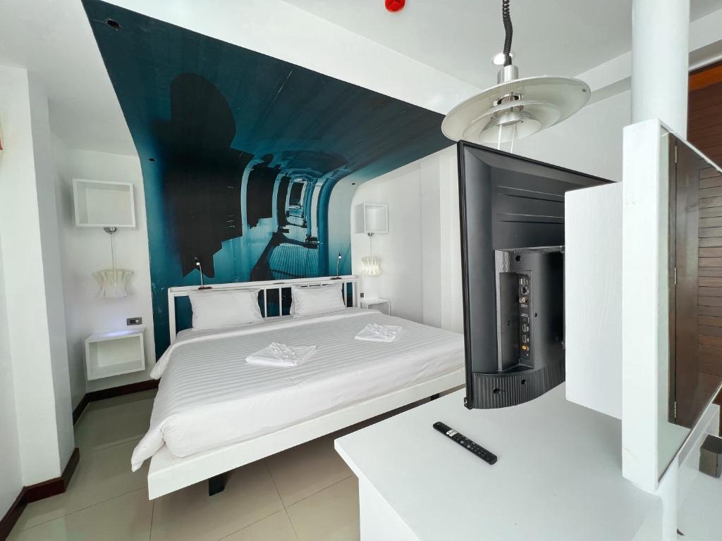 a bedroom with a bed with a fireplace in it at The Color Kata in Kata Beach