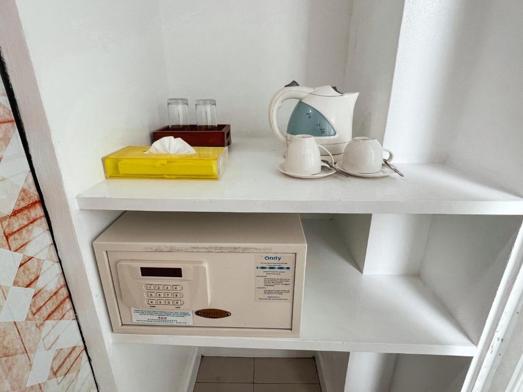 a microwave on a shelf in a kitchen at The Color Kata in Kata Beach
