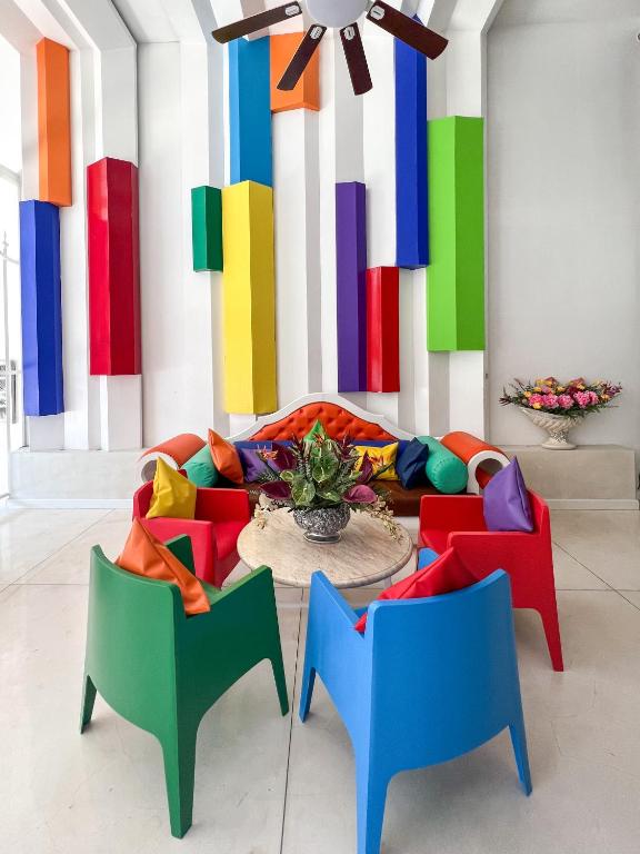 a room with a colorful couch and two chairs at The Color Kata in Kata Beach