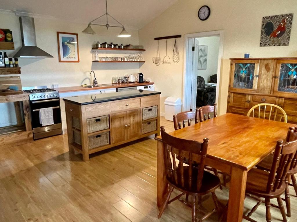 une cuisine avec une table en bois et une salle à manger dans l'établissement Ronald's Roost farmstay Kangaroo Island, à Wisanger