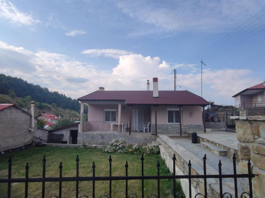 uma casa com uma cerca em frente em Primoula Grammou 1450 em Nea Kotili