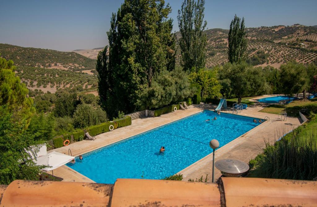 einen Blick über einen Pool mit Menschen darin in der Unterkunft Hotel del Carmen in Prado del Rey