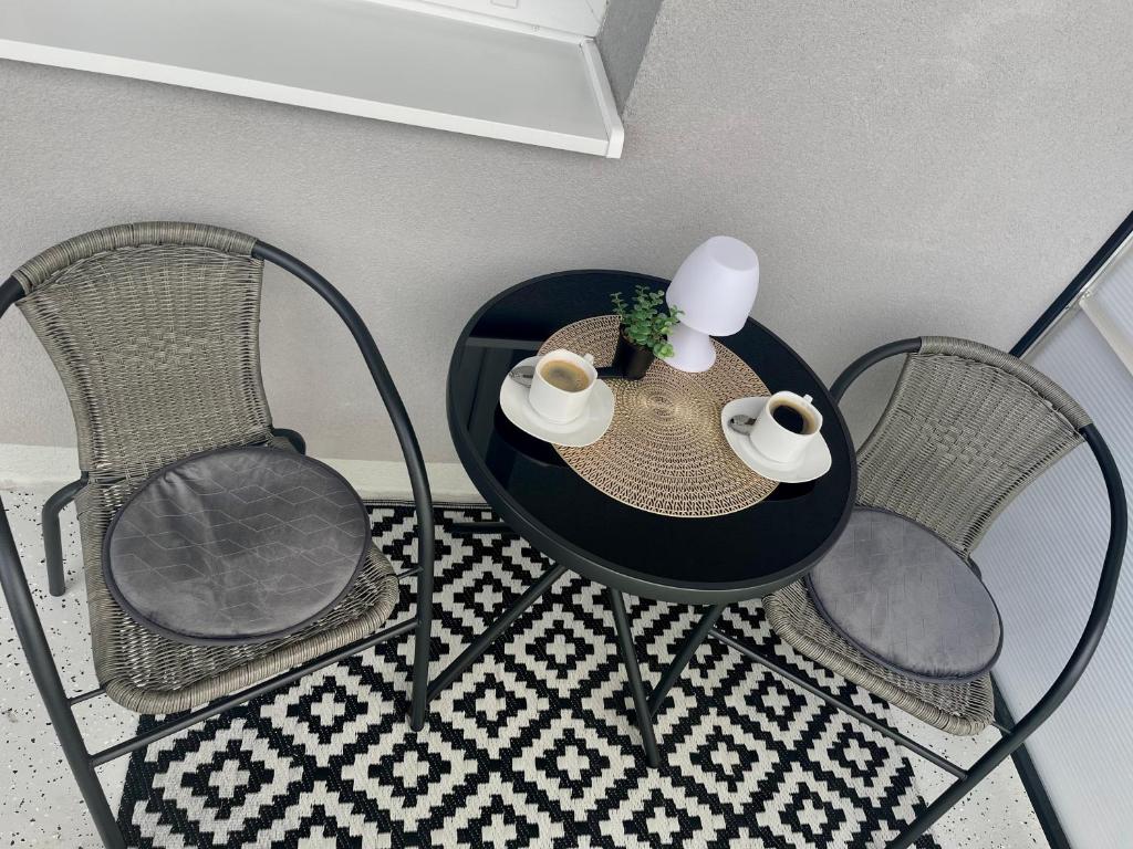 a table with two chairs and a table with two mugs at Apartmán pod Tatrami in Poprad