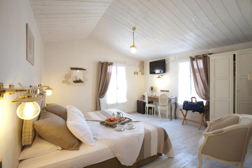 a room with a bed and a table in it at Chambre d'hôtes Hôte des Portes Île de Ré in Les Portes
