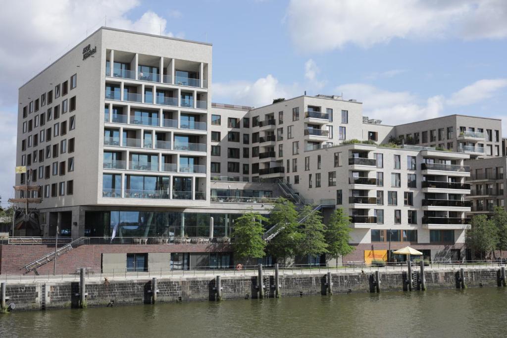 un groupe de bâtiments à côté d'une masse d'eau dans l'établissement JUFA Hotel Hamburg HafenCity, à Hambourg