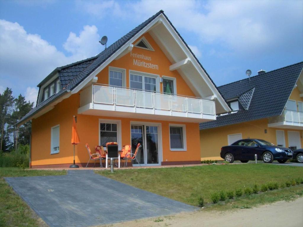 an orange house with a balcony at Ferienwohnungen Appartements - Ferienhaus Müritzstern in Marienfelde