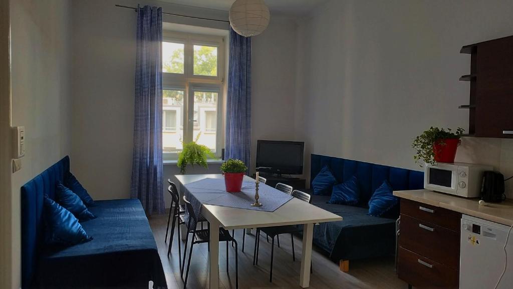 a living room with a table and a blue couch at Urban Nest Apartments Gertrudy 7 in Krakow