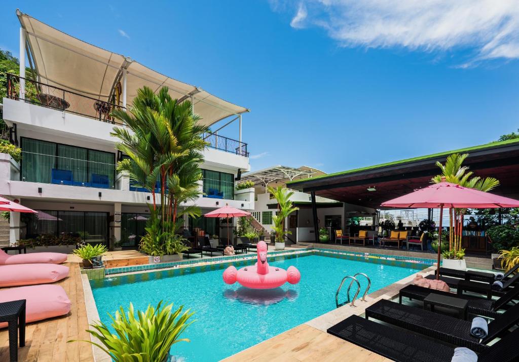 een zwembad met een roze praalwagen in een hotel bij CC's Hideaway Kata - SHA Plus in Kata Beach