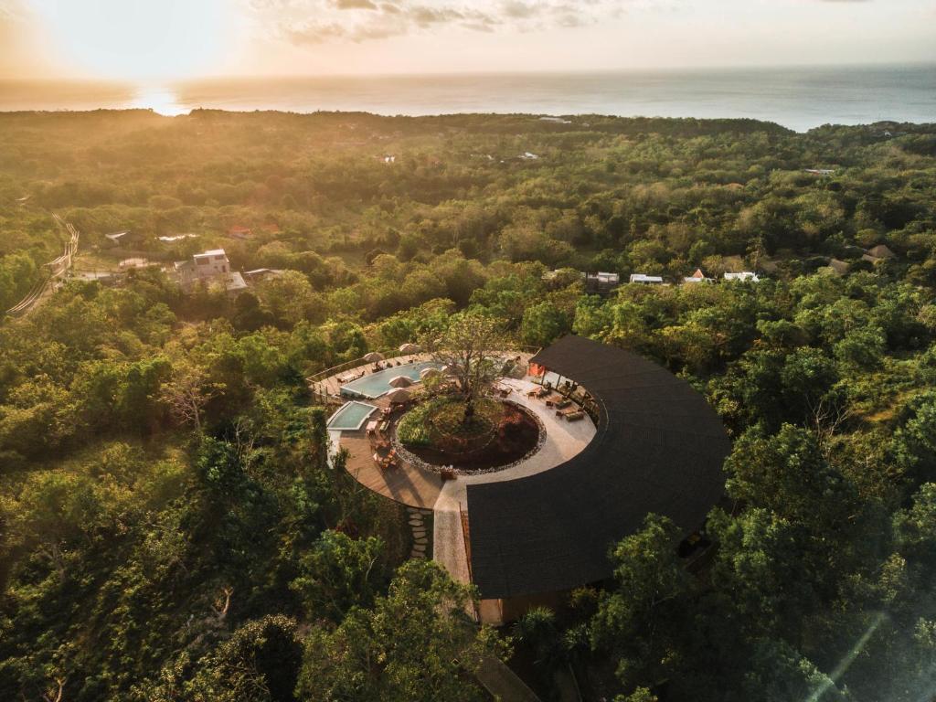 una vista aérea de un edificio circular con un árbol en el medio en Grün Resort Uluwatu en Uluwatu