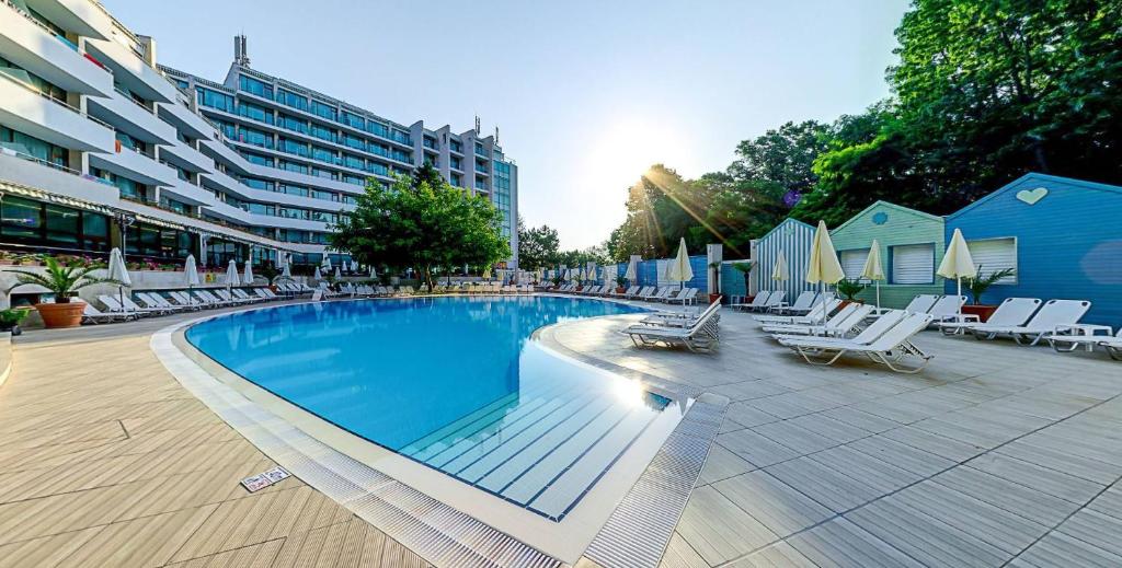 金沙的住宿－MiRaBelle Hotel - Half Board Plus & All Inclusive，一座带躺椅的游泳池和一座建筑