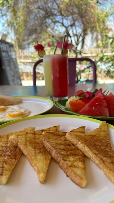 a plate of food with chips and fruit on a table at Meno Suites in Gili Meno