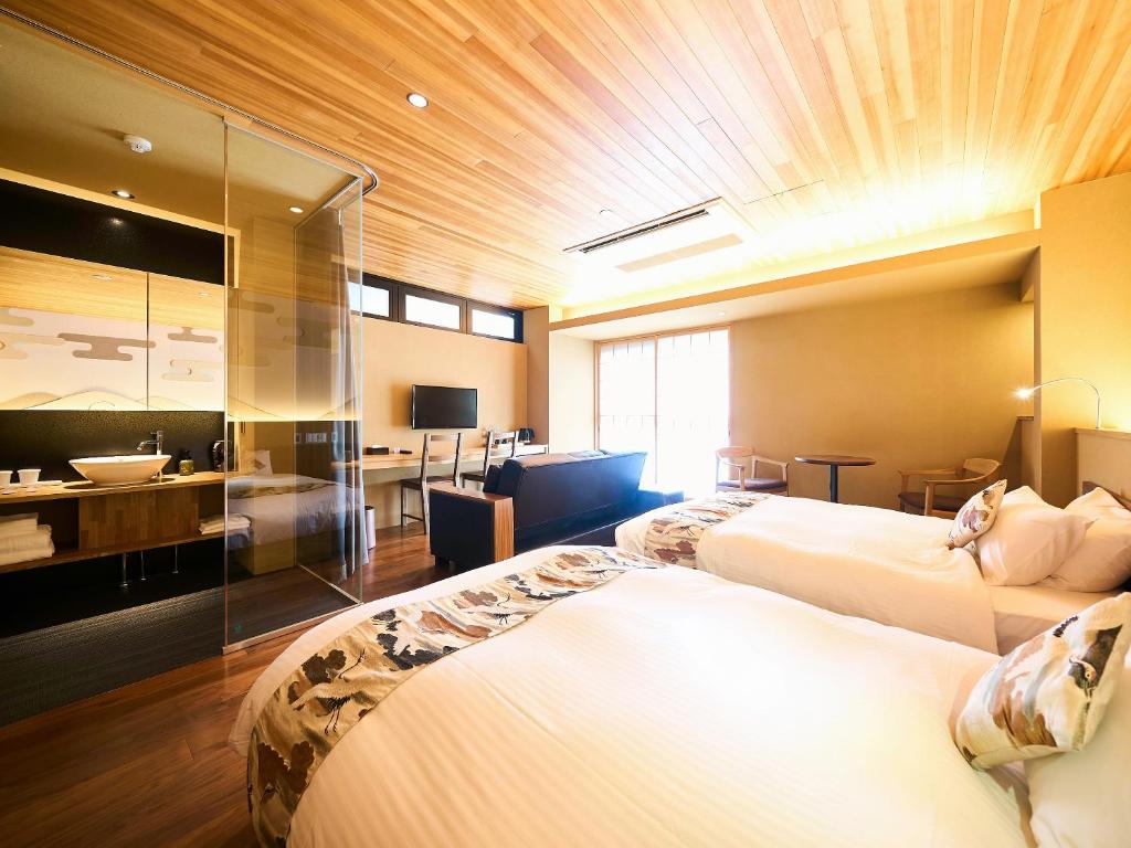 京都市にある枳殻の杜 Kikoku no moriのベッド2台とバスルームが備わるホテルルームです。