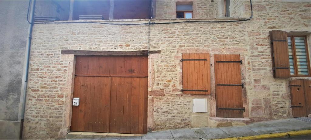 un edificio de ladrillo con puertas y ventanas de madera en Le Cocoon avec parking gratuit, en Cuisery