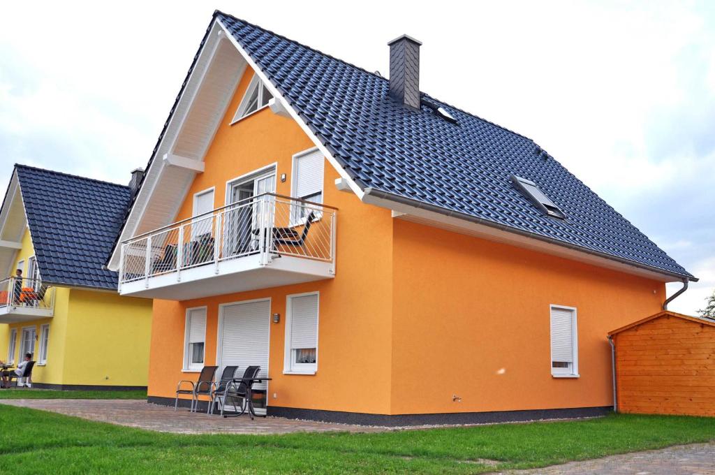 una casa de color naranja y amarillo en Ferienwohnungen Appartements - Ferienhaus Müritzwelle, en Marienfelde