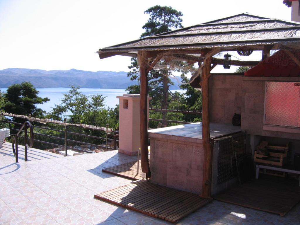 un cenador en un patio con vistas al agua en Lantana ex Villa Americana en Karlobag