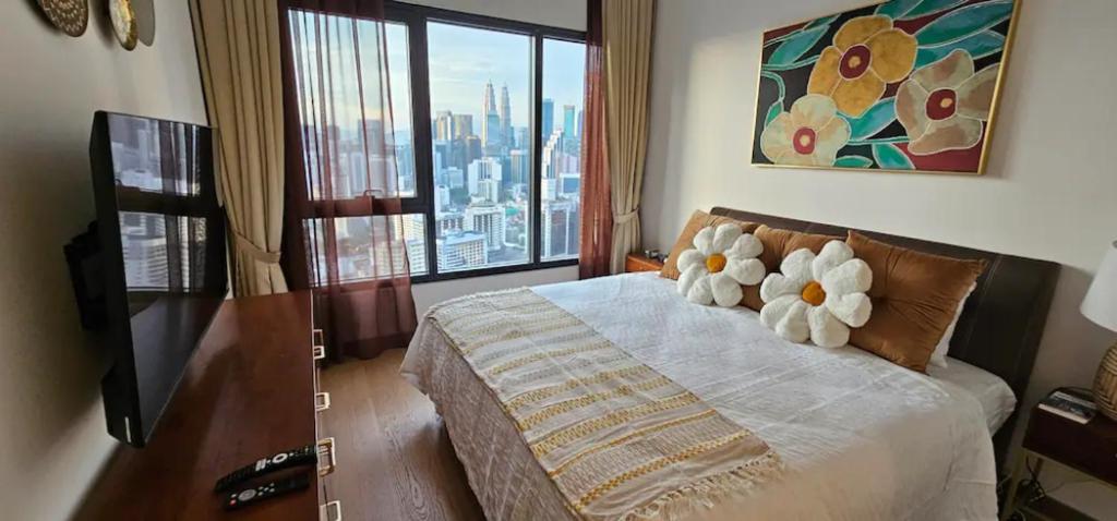 una camera da letto con un letto fiorito di Cozy Jr Suite -Amazing KL Skylines & Gorgeous pool a Kuala Lumpur