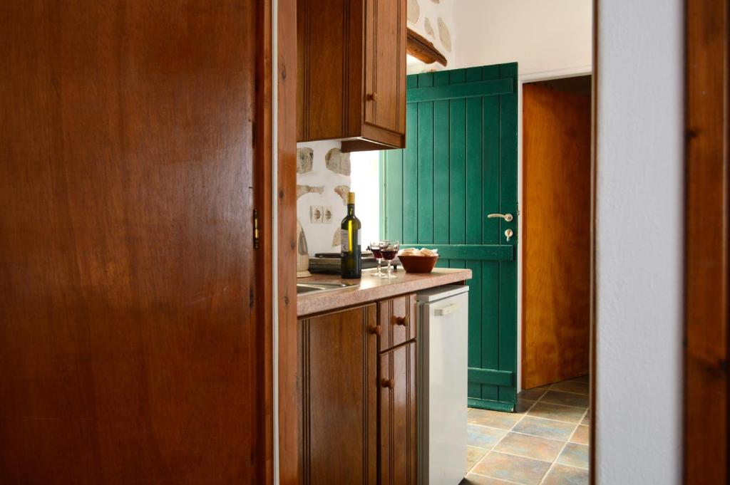 a kitchen with green cabinets and a white refrigerator at Villa Peristeri in Agios Georgios