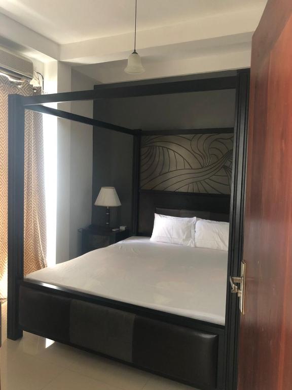 a bedroom with a large bed with a black frame at Randi Apartments B&B in Boralesgamuwa