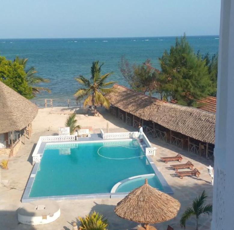 a view of a swimming pool and the ocean at Oluwa Seun Beach Cottages, Mtwapa in Mombasa