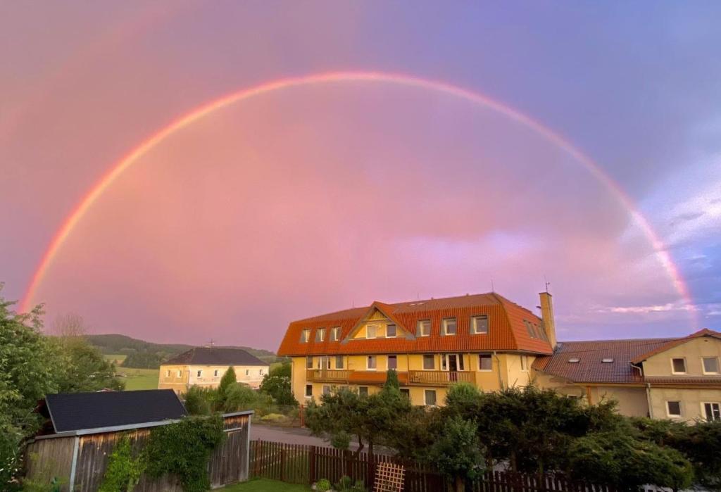 a rainbow in the sky over a house at Apartmán U AKVARISTY in Černá v Pošumaví