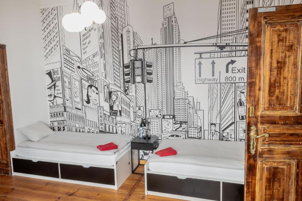 a bedroom with a wall mural of a city at Atelier Hostel in Leszno