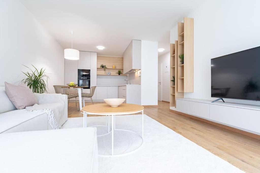 sala de estar blanca con sofá blanco y TV en Apartmán Al-Garden s private garage parking free, 5 min pešo do centra, en Košice